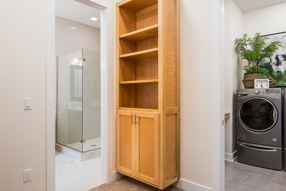 Inspiration for a large transitional gender-neutral walk-in wardrobe in Other with shaker cabinets, light wood cabinets, carpet and grey floor.