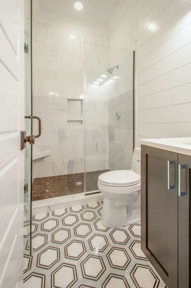 This is an example of a mid-sized modern kids bathroom in Nashville with shaker cabinets, black cabinets, an open shower, a one-piece toilet, white tile, white walls, ceramic floors, an undermount sink, quartzite benchtops, multi-coloured floor, a hinged shower door, white benchtops, an enclosed toilet, a double vanity, a built-in vanity, timber and planked wall panelling.