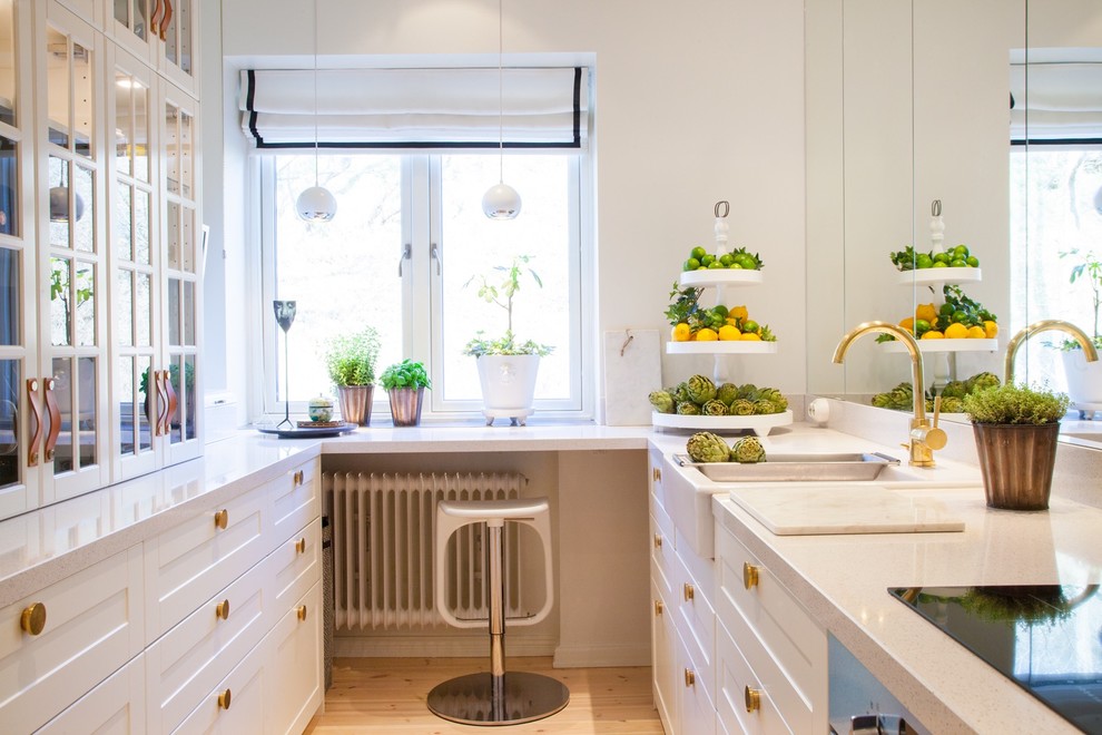 Inspiration for a large transitional galley kitchen in Malmo with a farmhouse sink, shaker cabinets, white cabinets, light hardwood floors, no island and granite benchtops.