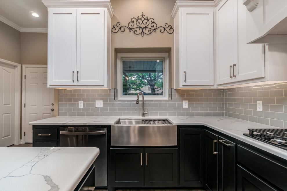 Foto på ett funkis vit kök, med en rustik diskho, luckor med infälld panel, bänkskiva i kvarts, grått stänkskydd, stänkskydd i keramik, svarta vitvaror, klinkergolv i keramik, en köksö och grått golv