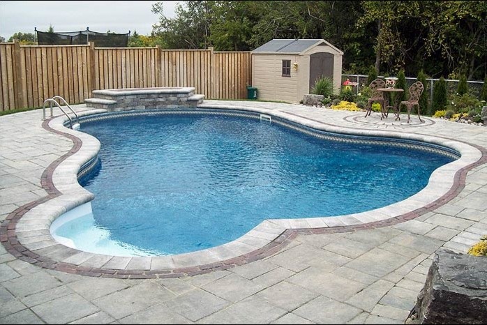 Mid-sized transitional backyard custom-shaped and concrete paver lap pool photo in Toronto
