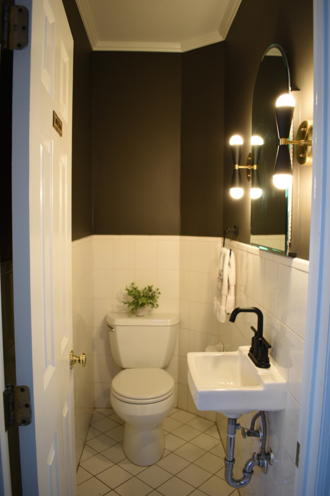 Small midcentury bathroom in New York with a two-piece toilet, white tile, porcelain tile, black walls, ceramic floors, a wall-mount sink, white floor and a single vanity.