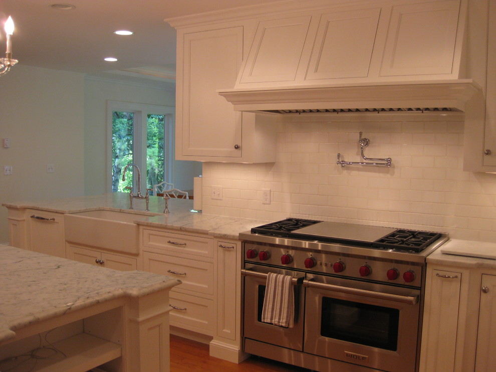 Eat-in kitchen - transitional u-shaped medium tone wood floor eat-in kitchen idea in Boston with a farmhouse sink, beaded inset cabinets, white cabinets, marble countertops, white backsplash, subway tile backsplash, stainless steel appliances and an island