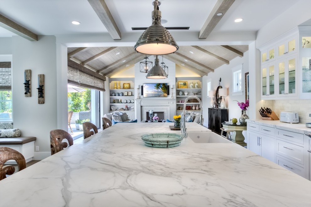 Design ideas for a large country l-shaped open plan kitchen in Orange County with a farmhouse sink, recessed-panel cabinets, white cabinets, marble benchtops, white splashback, subway tile splashback, stainless steel appliances, light hardwood floors and with island.