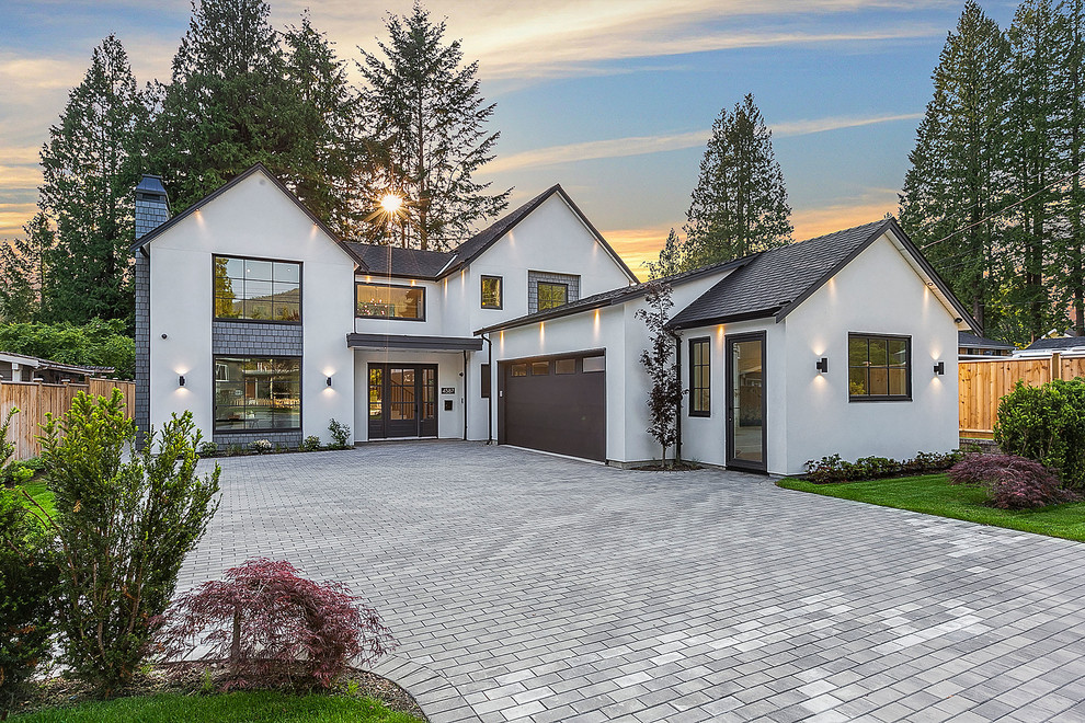 Inspiration for a large country two-storey stucco white exterior in Vancouver with a gable roof and a shingle roof.
