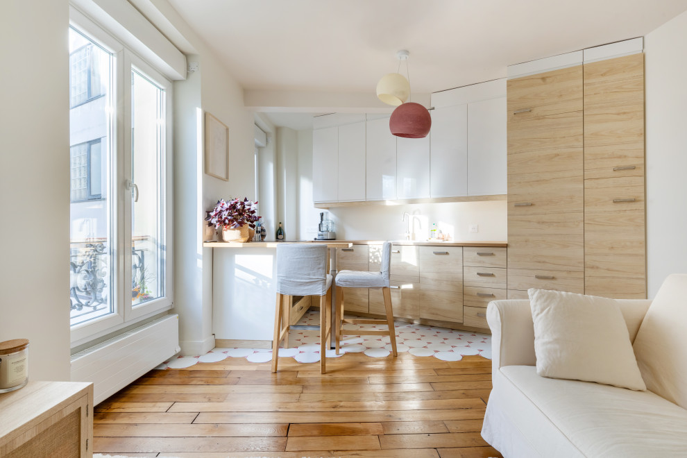 Inredning av ett modernt mellanstort beige beige kök, med en undermonterad diskho, luckor med profilerade fronter, skåp i ljust trä, träbänkskiva, integrerade vitvaror, klinkergolv i keramik, en halv köksö och vitt golv