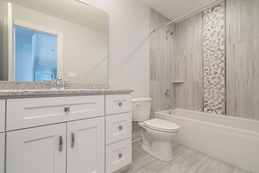 Design ideas for a mid-sized transitional kids bathroom in Chicago with white cabinets, a two-piece toilet, gray tile, porcelain tile, grey walls, porcelain floors, an undermount sink, grey floor, recessed-panel cabinets, an alcove shower, terrazzo benchtops, a sliding shower screen and grey benchtops.