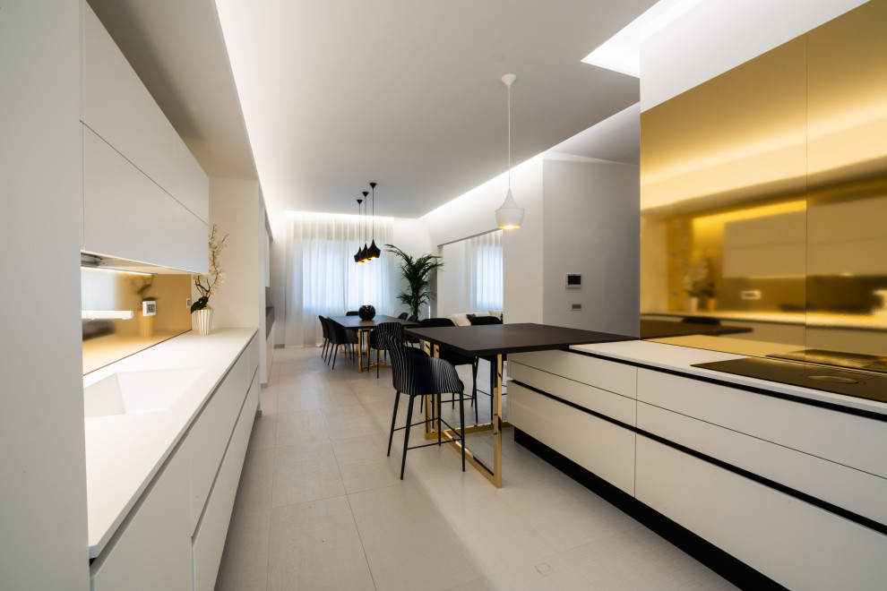 This is an example of a large contemporary galley open plan kitchen in Other with a double-bowl sink, flat-panel cabinets, white cabinets, quartzite benchtops, yellow splashback, stainless steel appliances, porcelain floors, with island, white floor, white benchtop and recessed.