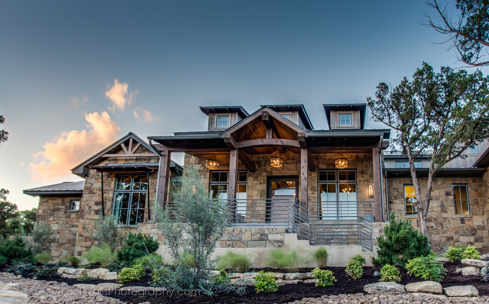 Large country two-storey beige exterior in Austin with stone veneer and a gable roof.