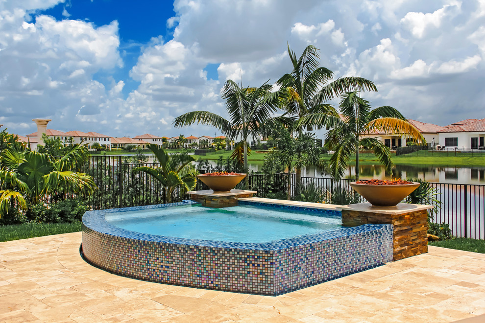 Small modern backyard custom-shaped aboveground pool in Miami with a hot tub and natural stone pavers.