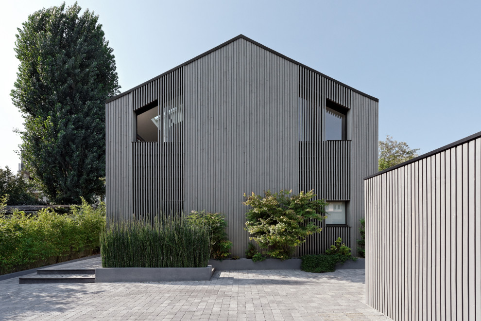 Идея дизайна: большой, трехэтажный, деревянный, серый частный загородный дом в современном стиле с двускатной крышей, металлической крышей, серой крышей и отделкой планкеном