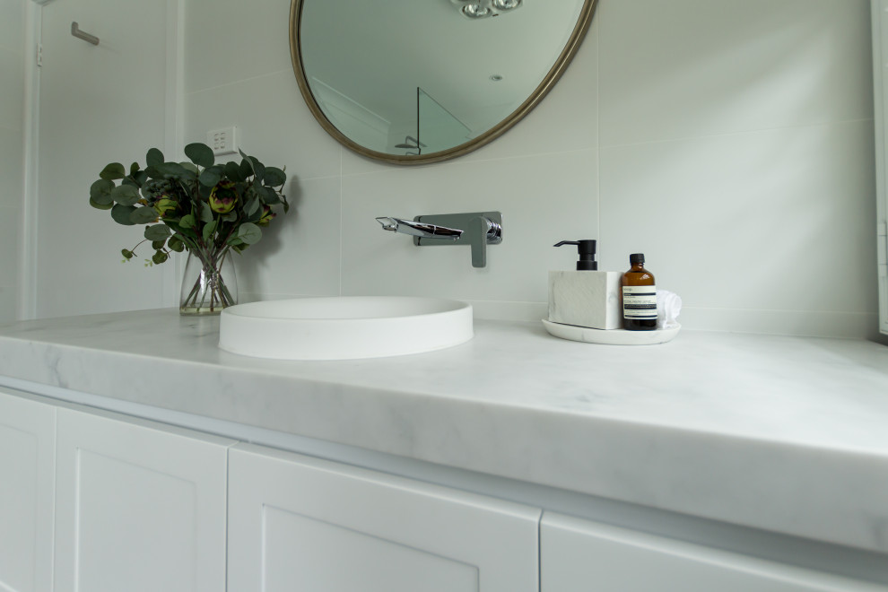This is an example of a mid-sized traditional master bathroom in Sydney with shaker cabinets, white cabinets, a corner tub, an open shower, white tile, a drop-in sink, an open shower, a niche, a single vanity and a floating vanity.