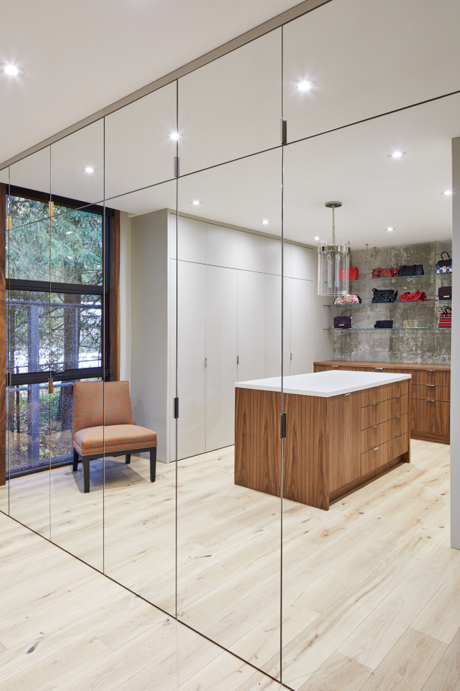 Inspiration for an expansive contemporary gender-neutral walk-in wardrobe in Toronto with flat-panel cabinets, medium wood cabinets, plywood floors and beige floor.