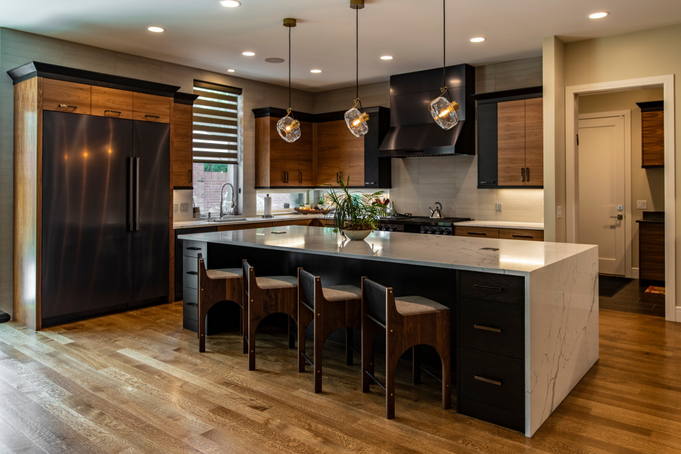 This is an example of a large contemporary kitchen/diner in Denver with flat-panel cabinets, medium wood cabinets, marble worktops, grey splashback, cement tile splashback, stainless steel appliances, medium hardwood flooring, an island, brown floors and white worktops.