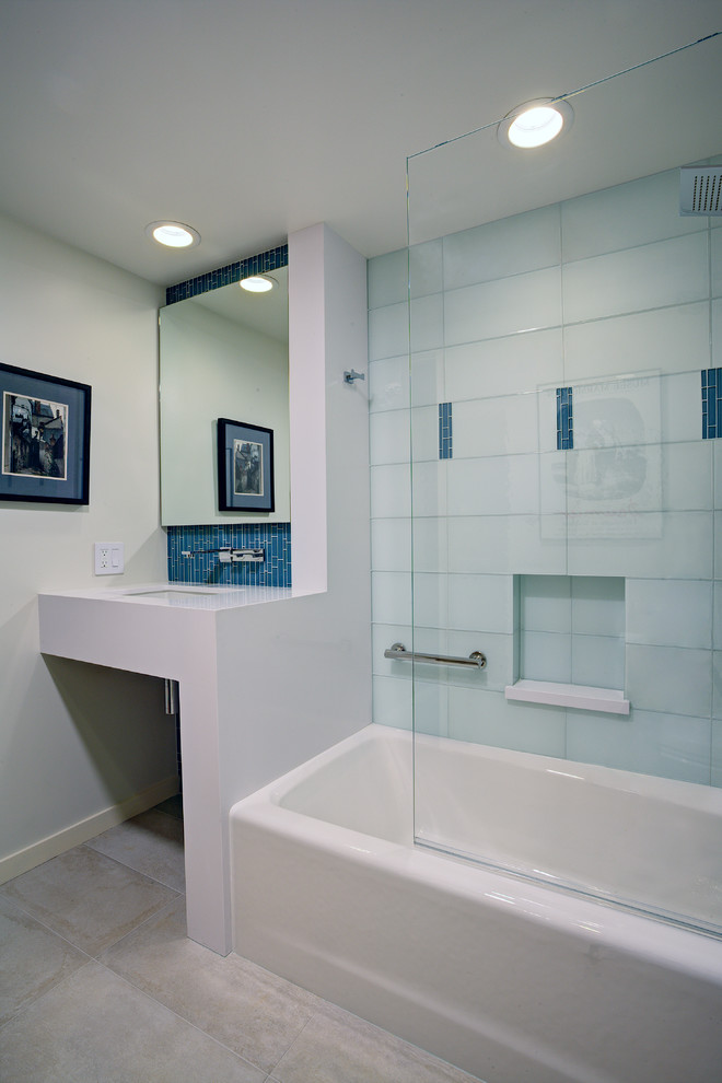 This is an example of a mid-sized contemporary 3/4 bathroom in San Francisco with an undermount sink, open cabinets, engineered quartz benchtops, an alcove tub, a shower/bathtub combo, a wall-mount toilet, blue tile, glass tile, porcelain floors, red walls, white cabinets, white floor and a hinged shower door.