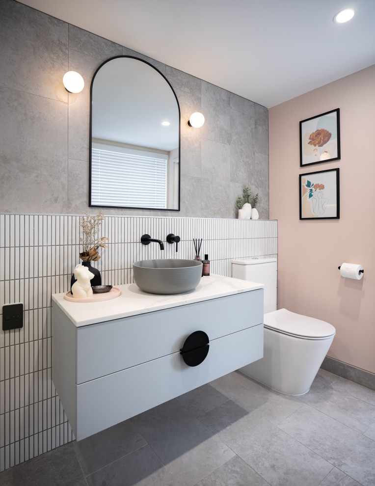 Design ideas for a small contemporary ensuite wet room bathroom in Auckland with blue cabinets, grey tiles, porcelain tiles, porcelain flooring, a vessel sink, engineered stone worktops, grey floors, white worktops, a single sink and a floating vanity unit.