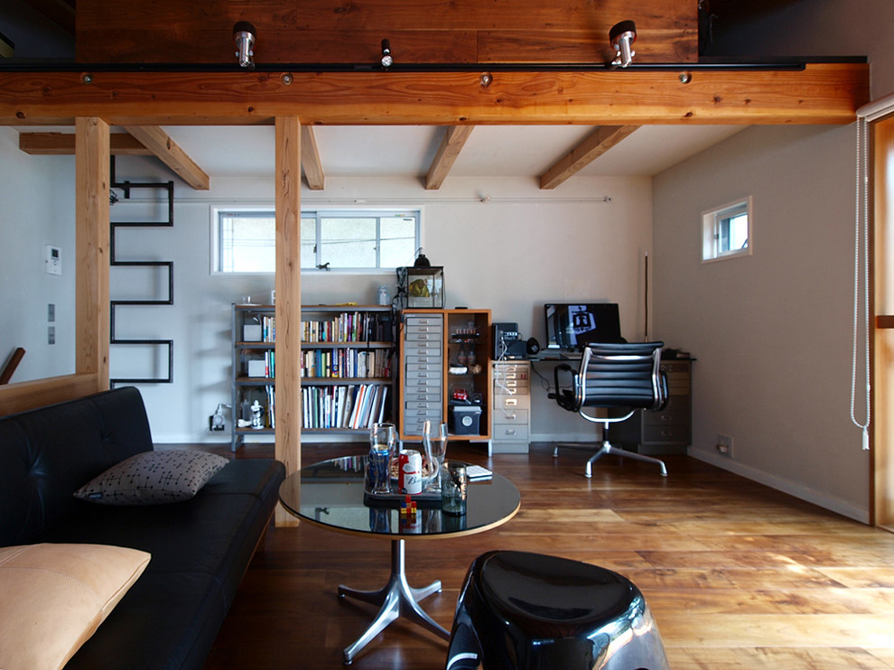 This is an example of a small midcentury home office in Tokyo with white walls, dark hardwood floors and brown floor.