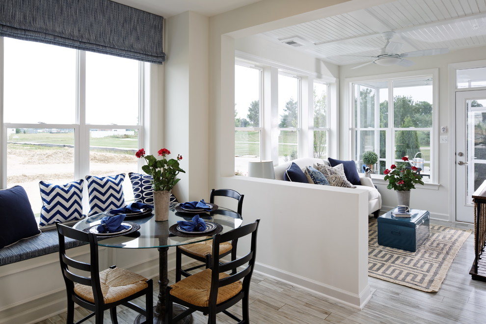 This is an example of a beach style dining room in DC Metro with white walls and light hardwood floors.