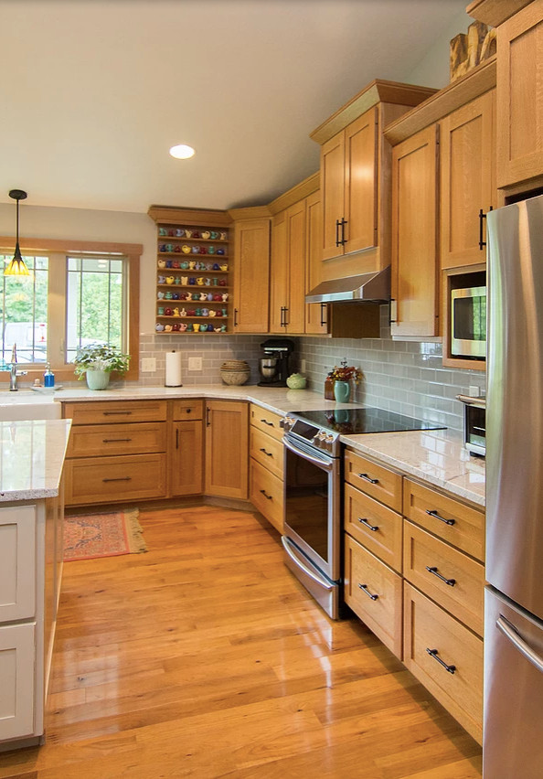 Mid-sized transitional l-shaped medium tone wood floor and brown floor open concept kitchen photo with a farmhouse sink, shaker cabinets, medium tone wood cabinets, quartzite countertops, gray backsplash, subway tile backsplash, stainless steel appliances, an island and white countertops