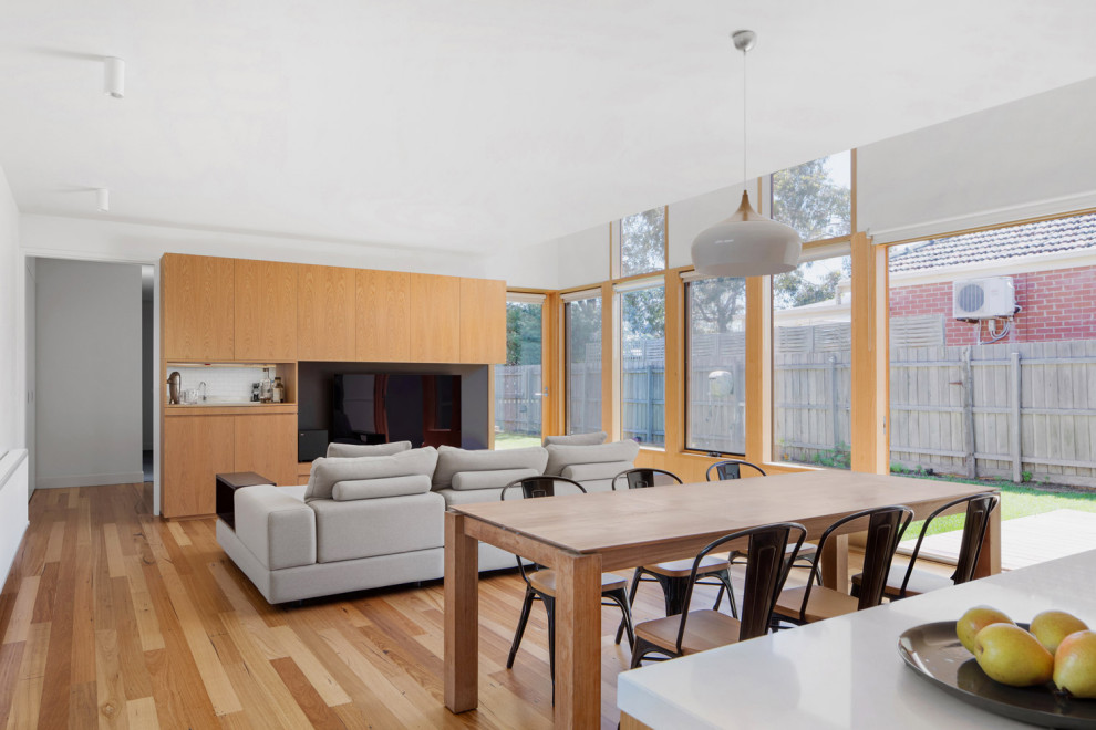 This is an example of a mid-sized contemporary open plan dining in Melbourne with white walls, light hardwood floors and no fireplace.