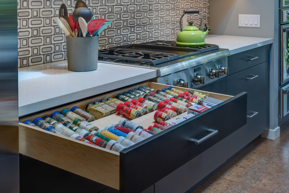 This is an example of a mid-sized contemporary galley eat-in kitchen in San Francisco with an undermount sink, flat-panel cabinets, dark wood cabinets, quartz benchtops, grey splashback, mosaic tile splashback, stainless steel appliances, cork floors and with island.