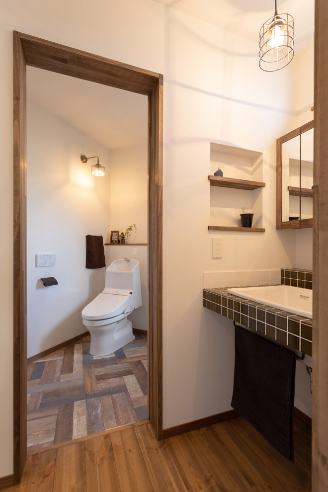 Источник вдохновения для домашнего уюта: туалет в скандинавском стиле с белыми фасадами, коричневой плиткой, керамогранитной плиткой и коричневой столешницей