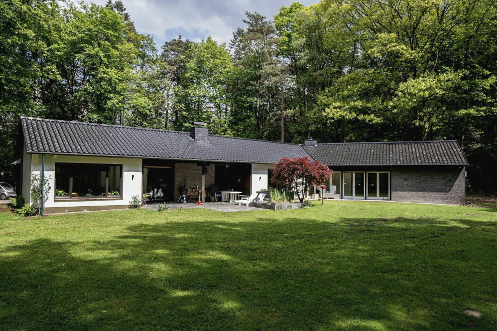 Gartenkamin im Sommer and neben dem Haus With Kamin, Natursteinplatten and Metallzaun in Dusseldorf