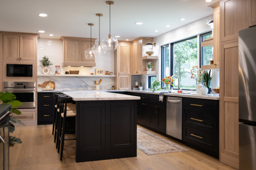 Inspiration for a mid-sized transitional l-shaped medium tone wood floor and brown floor kitchen remodel in Baltimore with light wood cabinets, quartzite countertops, an undermount sink, shaker cabinets, white backsplash, stone slab backsplash, stainless steel appliances, an island and white countertops