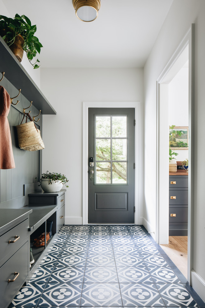 Design ideas for a transitional mudroom in Grand Rapids with white walls, porcelain floors, a single front door, a black front door and black floor.