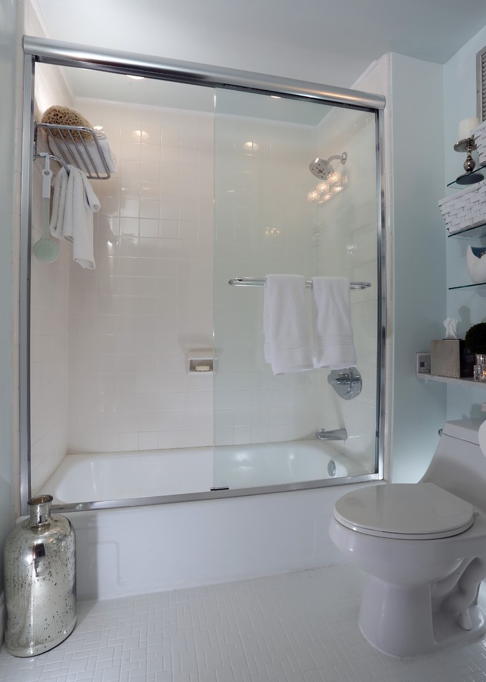This is an example of a mid-sized beach style 3/4 bathroom in Miami with recessed-panel cabinets, white cabinets, an alcove tub, a shower/bathtub combo, a one-piece toilet, gray tile, matchstick tile, blue walls, mosaic tile floors, a vessel sink, laminate benchtops, white floor and a sliding shower screen.