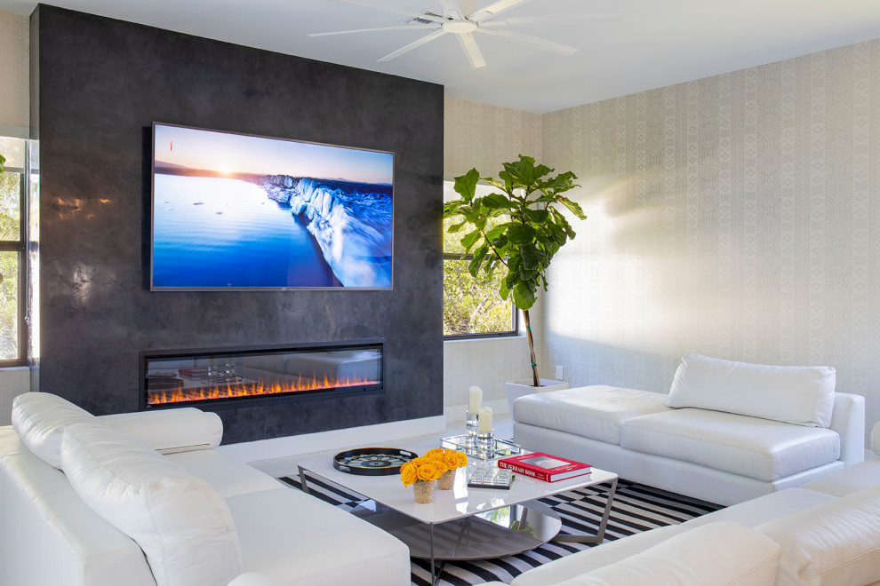 Photo of a large modern open concept family room in Miami with a game room, beige walls, marble floors, a hanging fireplace, a plaster fireplace surround, a wall-mounted tv and white floor.
