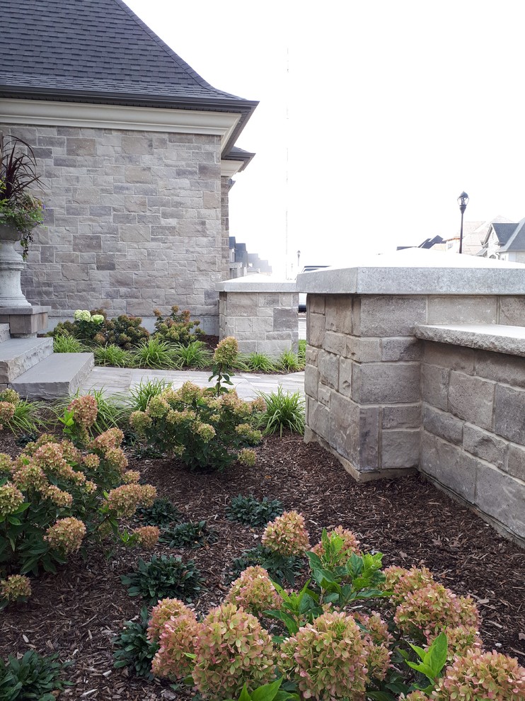 Inspiration for a mid-sized transitional front yard concrete paver formal garden.