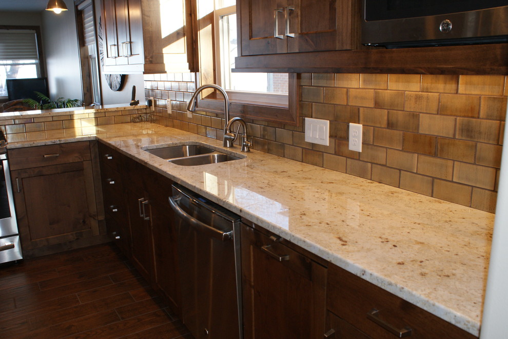 Example of a mid-sized transitional l-shaped porcelain tile open concept kitchen design in Minneapolis with an undermount sink, recessed-panel cabinets, beige cabinets, metallic backsplash, ceramic backsplash, stainless steel appliances and a peninsula