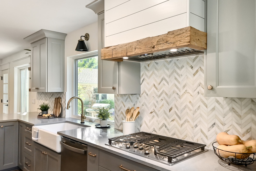 Huge cottage l-shaped medium tone wood floor and brown floor eat-in kitchen photo in Milwaukee with a farmhouse sink, shaker cabinets, gray cabinets, quartz countertops, white backsplash, marble backsplash, stainless steel appliances, an island and gray countertops
