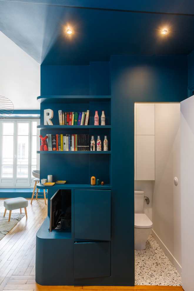 Idéer för att renovera en liten funkis farstu, med blå väggar, ljust trägolv, en enkeldörr och en blå dörr