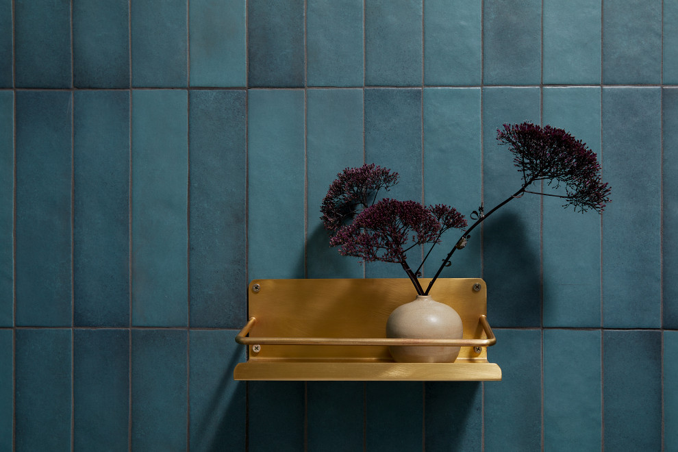 Inspiration for a small midcentury bathroom in San Francisco with a curbless shower, a one-piece toilet, blue tile, ceramic tile, blue walls, ceramic floors, a wall-mount sink, limestone benchtops, grey floor, a hinged shower door, black benchtops, a single vanity, a floating vanity and exposed beam.