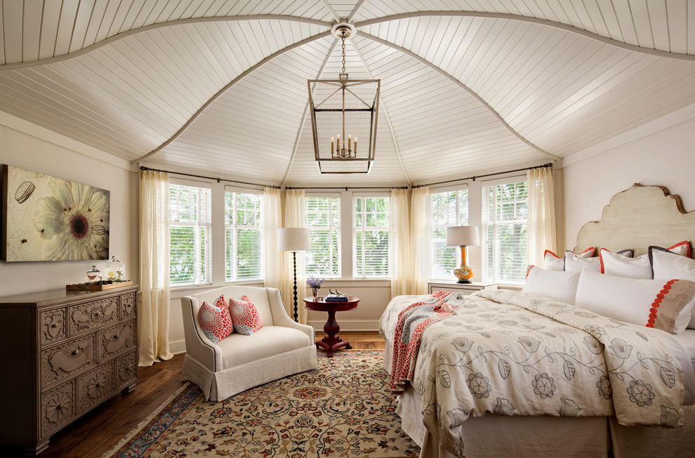 This is an example of a country master bedroom in Milwaukee with beige walls and medium hardwood floors.