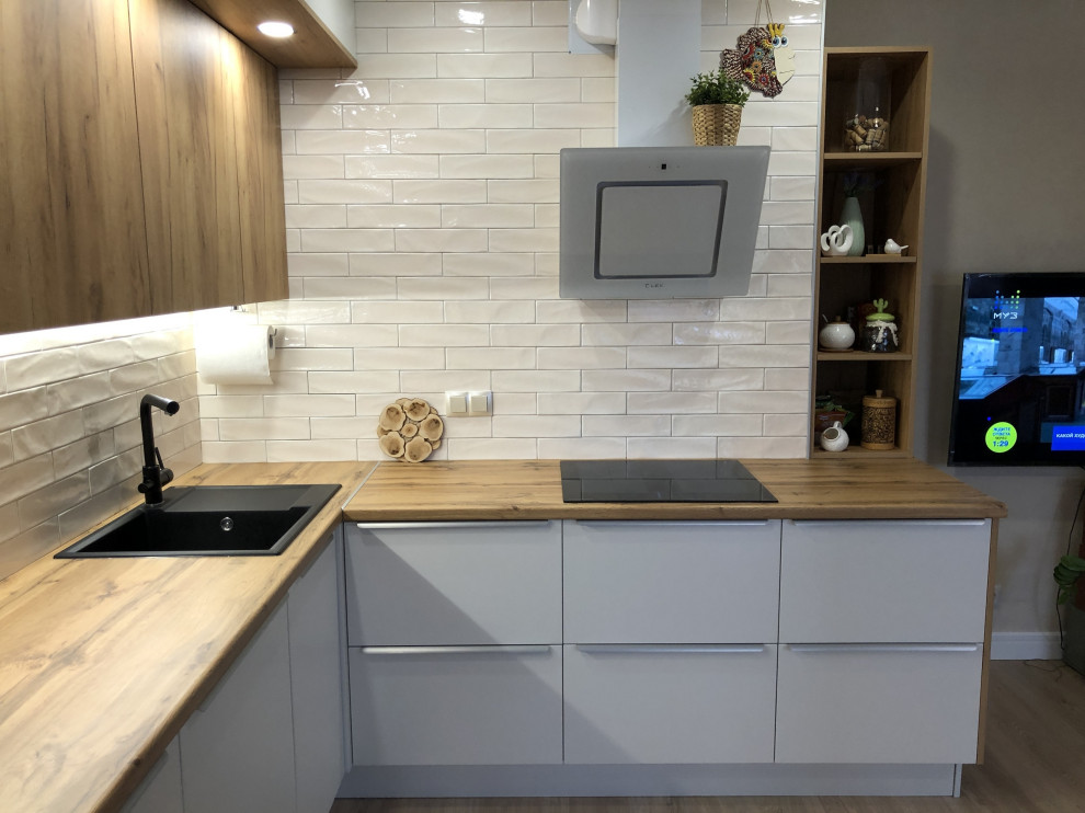 This is an example of a medium sized contemporary l-shaped open plan kitchen in Moscow with a built-in sink, flat-panel cabinets, medium wood cabinets, laminate countertops, beige splashback, ceramic splashback, no island and brown worktops.