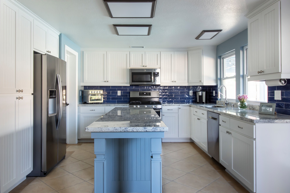 Mid-sized transitional galley separate kitchen in Los Angeles with a single-bowl sink, beaded inset cabinets, white cabinets, granite benchtops, blue splashback, ceramic splashback, stainless steel appliances, ceramic floors, with island, beige floor and blue benchtop.