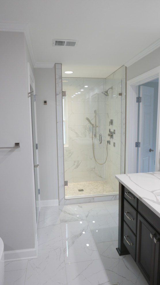 This is an example of a mid-sized transitional master bathroom in Other with shaker cabinets, dark wood cabinets, a freestanding tub, an alcove shower, a bidet, white tile, porcelain tile, beige walls, porcelain floors, an undermount sink, engineered quartz benchtops, white floor, a hinged shower door, white benchtops, an enclosed toilet, a double vanity and a floating vanity.
