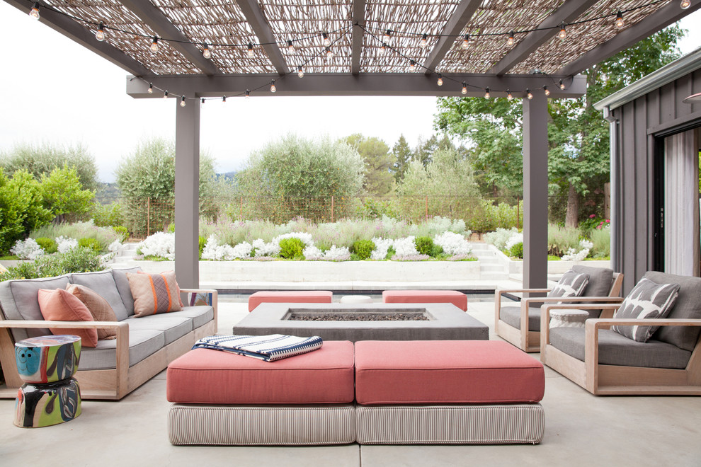 Inspiration for a transitional patio in San Francisco with a fire feature, concrete slab and a pergola.