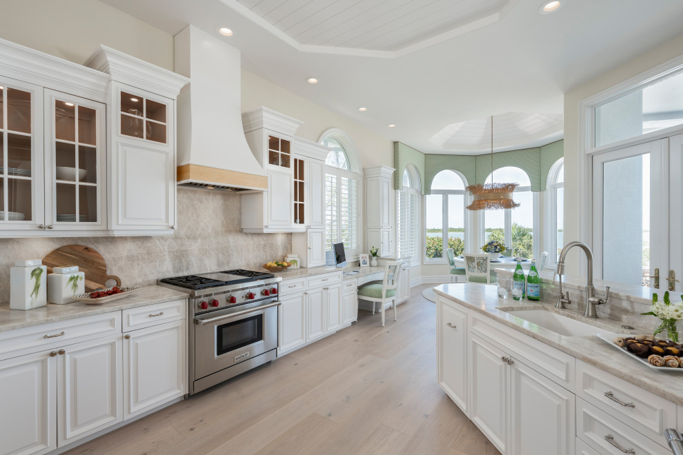 Eat-in kitchen - large transitional light wood floor, beige floor and shiplap ceiling eat-in kitchen idea with an undermount sink, raised-panel cabinets, white cabinets, quartzite countertops, beige backsplash, stone slab backsplash, stainless steel appliances, an island and beige countertops