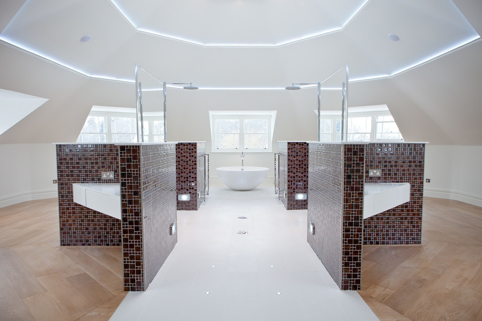 Contemporary bathroom in Sussex with a wall-mount sink, a freestanding tub, a curbless shower, brown tile, mosaic tile, white walls and light hardwood floors.