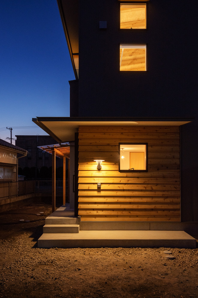 Inspiration för ett litet nordiskt grått hus i flera nivåer, med pulpettak och tak i metall