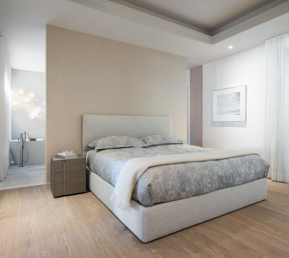 Ejemplo de dormitorio principal actual de tamaño medio con suelo de madera clara