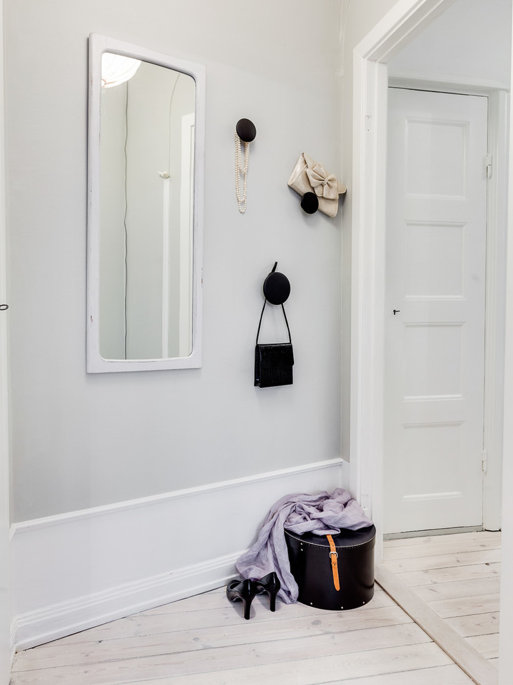 Design ideas for a scandinavian hallway in Stockholm with white walls and painted wood floors.