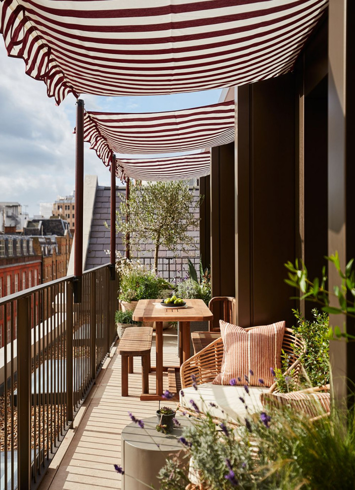 Design ideas for an eclectic metal railing balcony in London with an awning.