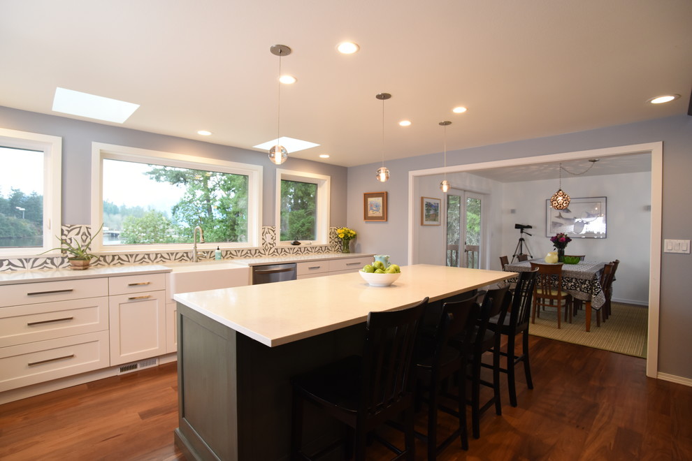 Inspiration for a mid-sized transitional l-shaped eat-in kitchen in Seattle with a farmhouse sink, shaker cabinets, white cabinets, quartzite benchtops, multi-coloured splashback, ceramic splashback, stainless steel appliances, medium hardwood floors and with island.