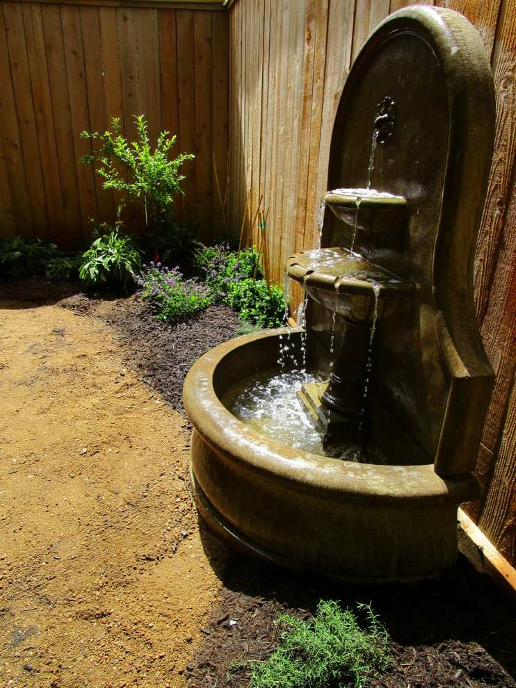 Design ideas for a small mediterranean backyard partial sun xeriscape in Houston with a water feature and gravel.
