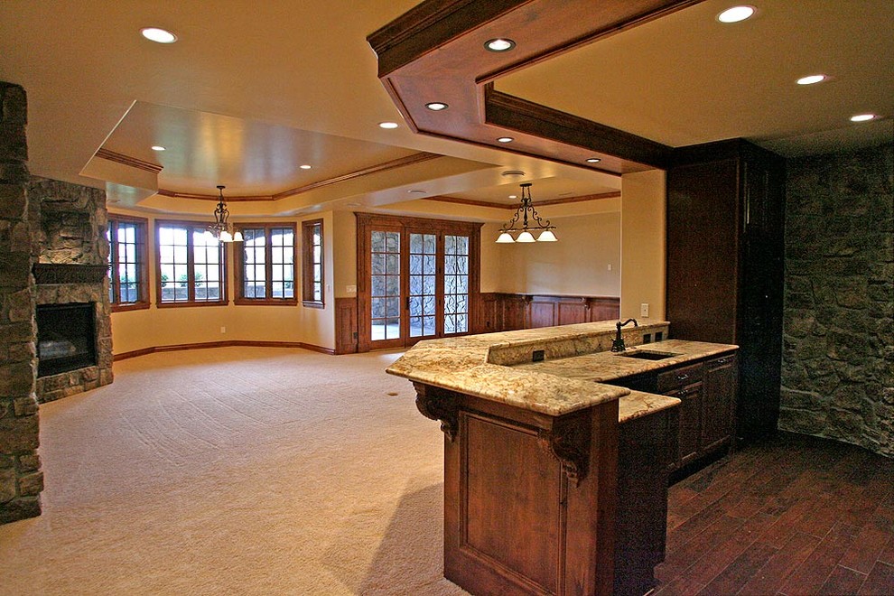 Inspiration for a large mediterranean home bar in Denver with dark wood cabinets and granite benchtops.